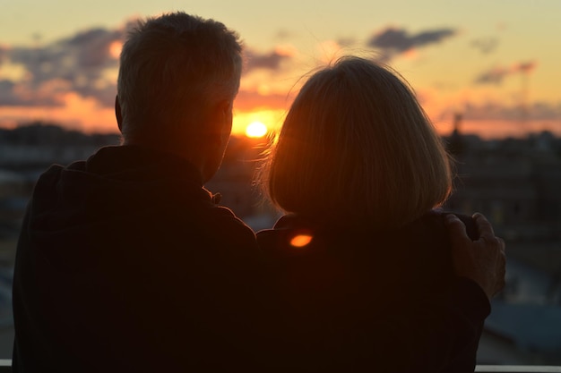 Gelukkig bejaarde echtpaar op tropisch strand bij zonsondergang