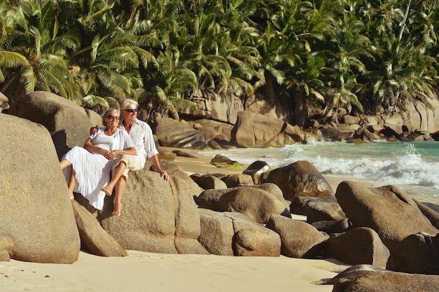 Gelukkig bejaarde echtpaar zittend op tropisch strand