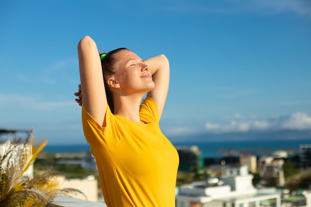 Gelukkig blij positief meisje jong mooi gevoel zorgeloos vrouw geniet van vakantie op zonnige zomerdag zonnebaden looien en glimlachen Geluk vrijheid concept op natuurlijke hemelachtergrond