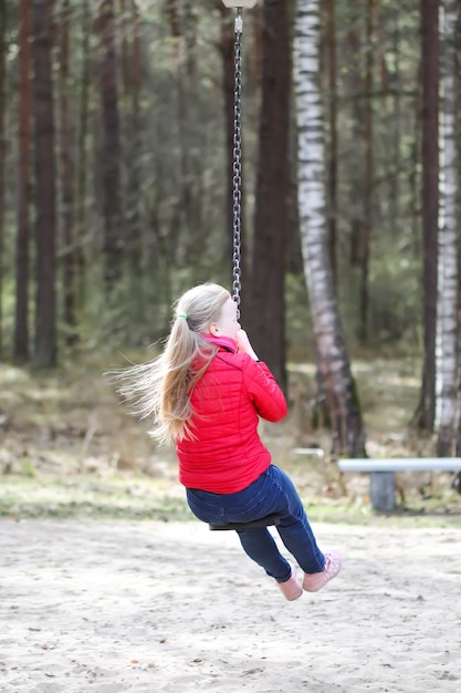 Gelukkig blond tienermeisje dat met bungee in park springt