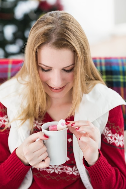 Gelukkig blonde in de winterkleren die mok houden