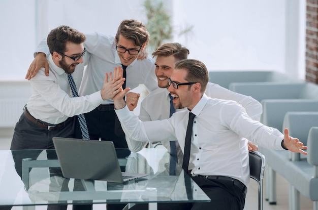 Gelukkig business team kijkt naar het opstarten van het laptopscherm