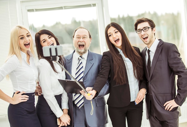 Gelukkig business team maakt een selfie bij het raam op kantoor