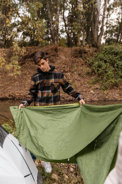 Gelukkig camping man in het bos maken van de tent