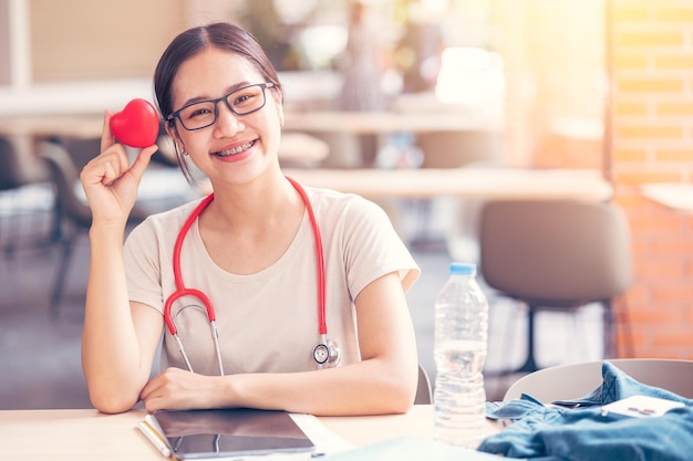 Gelukkig cardio arts student met rood hart teken voor het delen van liefde gezondheidszorg aan mensen concept