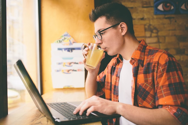 Gelukkig casual man met laptopcomputer in café