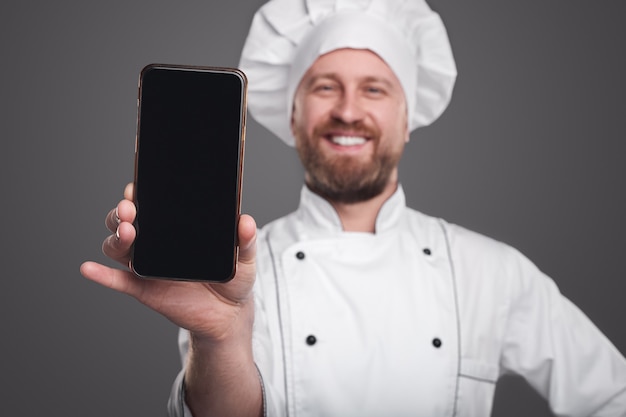 Gelukkig chef-kok smartphone tonen op camera