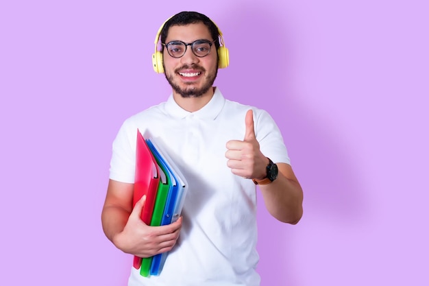 Gelukkig college student met mappen draadloze hoofdtelefoons en het maken van een signaal