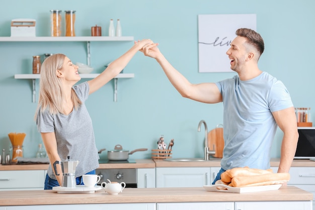 Gelukkig dansend jong koppel in de keuken