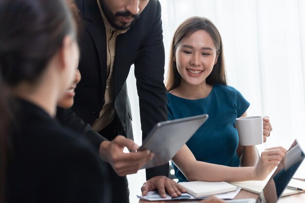 Gelukkig diverse zakenmensen werken samen bespreken in hoofdkantoor Professioneel en diversiteitsteamwerk bespreken businessplan op bureau met laptop Moderne multiculturele kantoormedewerker Concord