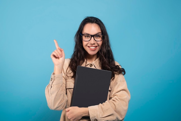 Gelukkig duizendjarige europese studente in glazen knuffel laptop wijzende vinger naar lege ruimte