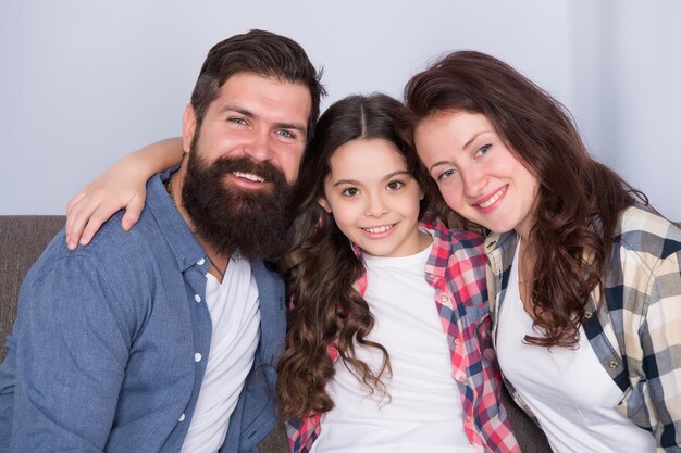 Gelukkig een familievertrouwen en relatieve banden te zijn bebaarde man en vrouw met kind gelukkig gezin ontspannen thuis familieweekend moeder en vader liefde dochter klein meisje met ouders familie thuis