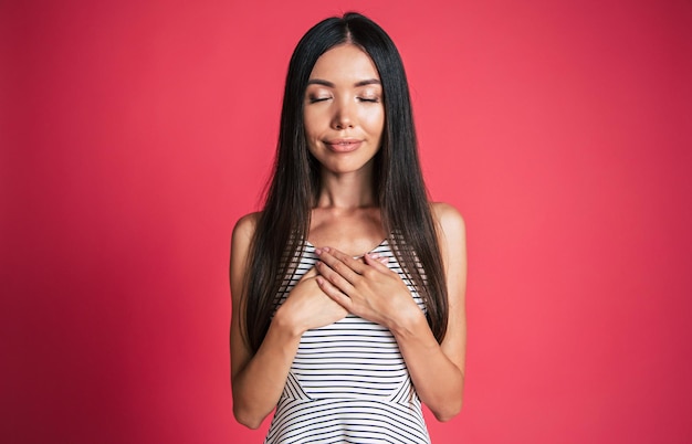 Gelukkig en opgewonden mooie jonge Aziatische vrouw portret geïsoleerd op roze achtergrond. Mensen emoties concept