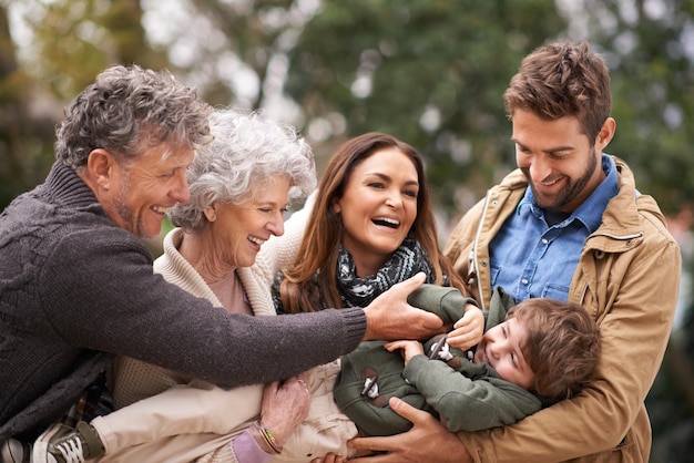 Gelukkig familiekind en mensen spelen met kind in een park op vakantie in de buitenlucht en opgewonden samen Grootouders geluk en ouders spelen met kind als liefdeszorg en binding in de natuur