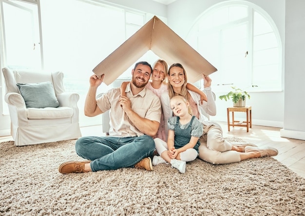 Gelukkig familieportret en kartonnen dak voor verhuizen in vastgoedbeleggingen of onroerend goed in een nieuw huis Moeder, vader en kinderen glimlachen voor onderdak appartement of verhuizing samen op huishypotheek