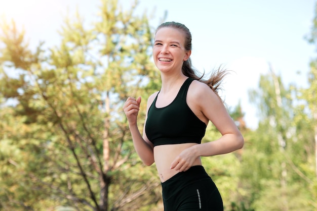 Gelukkig fit fitness meisje runner hardlopen joggen jonge mooie vrouw lacht training buitenshuis