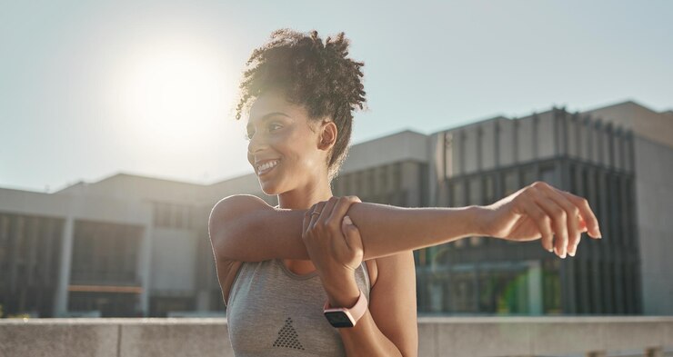 Foto gelukkig fitness en stretchen met een gezonde vrouw die klaar is om in de zomer buiten te trainen glimlach gezondheid en oefen met een jonge vrouwelijke atleet die haar opwarmingsroutine doorloopt voor training