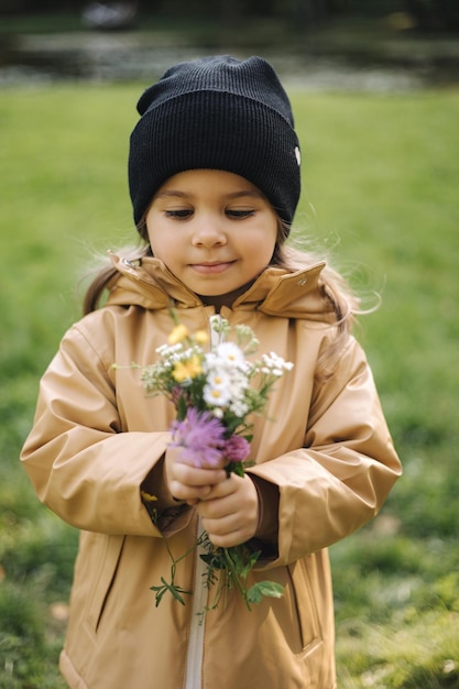 Gelukkig geglimlacht meisje plukte herfstbloemen mooie dochter in herfstbos