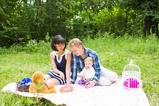 Foto gelukkig gemengd ras familie picknicken en spelen in het park.