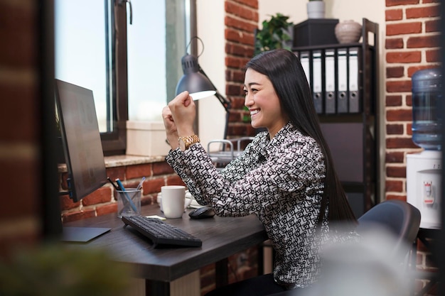 Gelukkig gemotiveerde kantoormedewerker tevreden met goede resultaten van promotiecampagne. Dolblije projectmanager die jobpromotie en succesvolle deal viert door krachtig de vuist op te heffen.