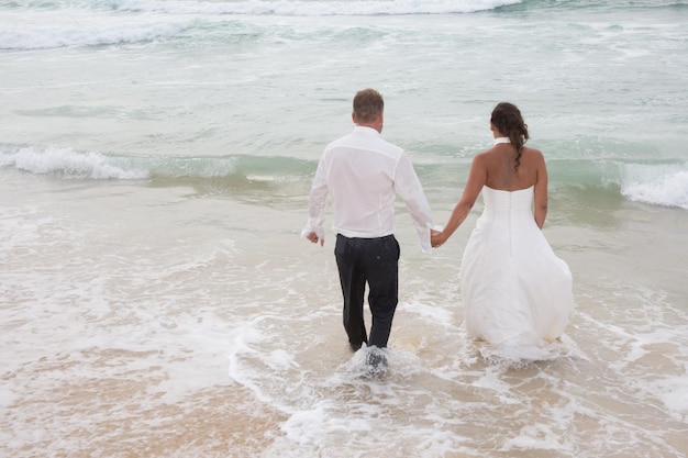 Gelukkig getrouwd stel staande op het strand