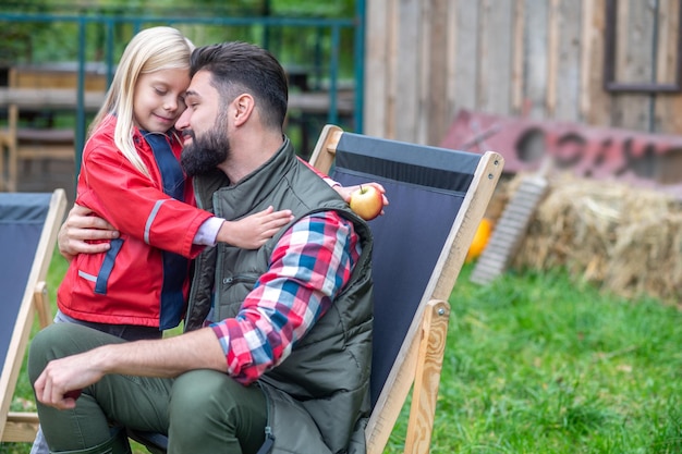 Gelukkig gezin. Een schattig blond meisje dat haar vader knuffelt en er allebei gelukkig uitziet