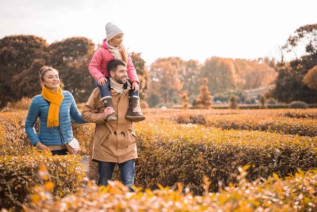 Gelukkig gezin met één kind wandelen in prachtig herfstpark