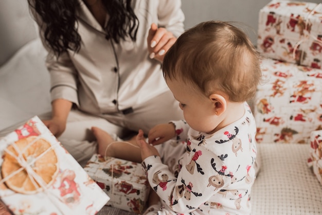 Gelukkig gezin met kind dat Nieuwjaar en Kerstmis viert bij versierde kerstboom en slingers