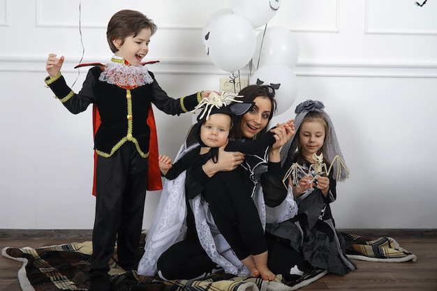 Gelukkig gezin met kinderen in kostuums van heks en vampier in een huis in vakantie Halloween