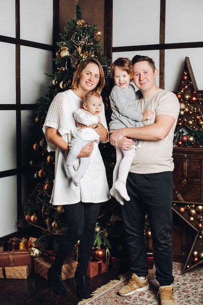Gelukkig gezin met twee kinderen op kerstboom.