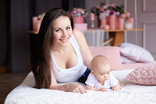 Gelukkig gezin. moeder met haar kleine baby in de slaapkamer