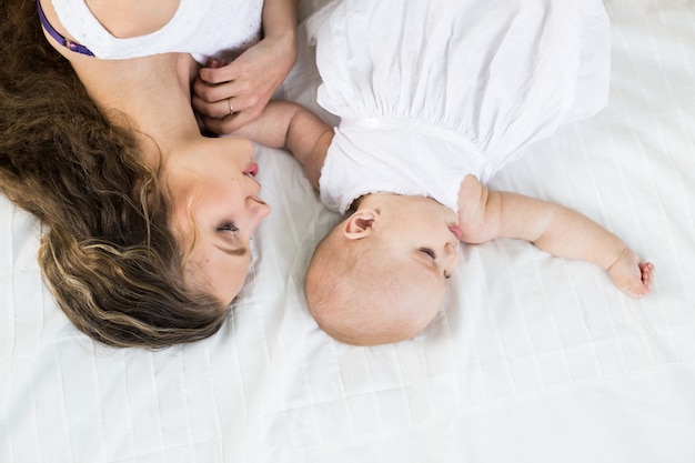 gelukkig gezin. moeder speelt met haar baby in de slaapkamer.