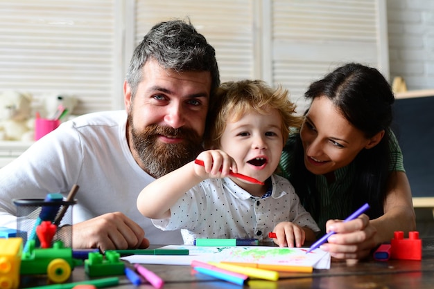 Gelukkig gezin moeder vader en kind tekenen Gelukkig gezin met kinderen in het weekend Jonge ouders en hun kind zijn erg blij thuis Kinderen vroege kunst- en ambachtsonderwijs tekenen