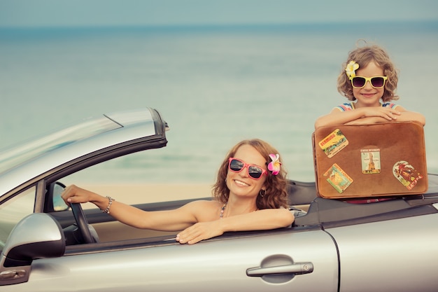 Gelukkig gezin reist met de auto naar de zee Vrouw en kind hebben plezier in cabriolet Zomervakantie concept