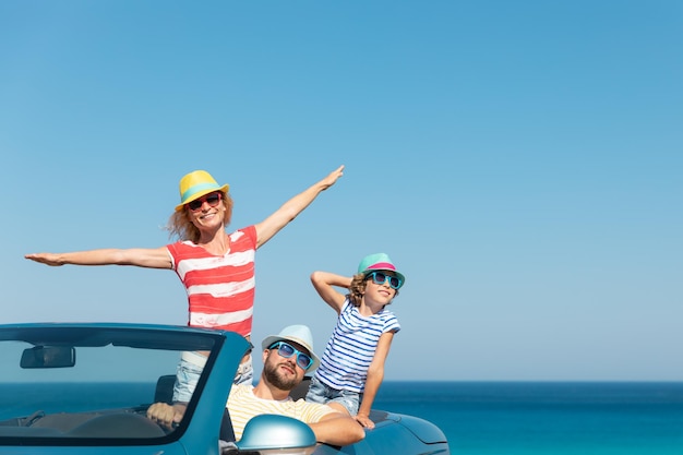 Gelukkig gezin reizen met de auto aan zee Moeder vader en dochter hebben plezier in blauwe cabriolet Zomervakantie concept