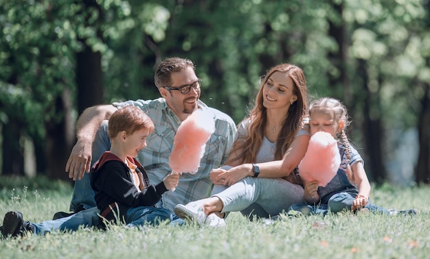 Foto gelukkig gezin rusten op het gazon in de stad parkthe concept van familie-entertainment