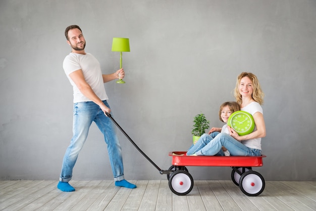 Gelukkig gezin speelt in nieuw huis Vader moeder en kind hebben samen plezier Verhuisdag