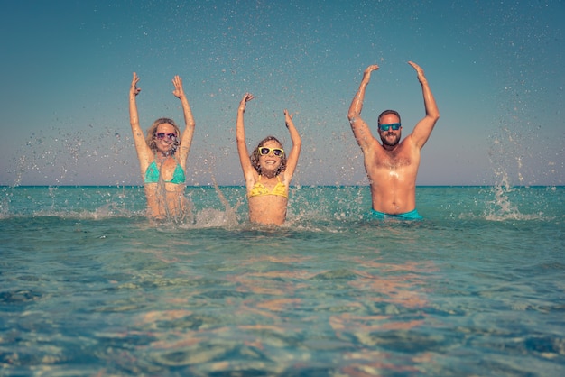 Gelukkig gezin spelen in de zee Kind moeder en vader plezier op zomervakantie Gezonde actieve levensstijl concept