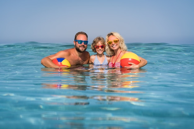 Gelukkig gezin spelen in de zee Kind moeder en vader plezier op zomervakantie Gezonde actieve levensstijl concept