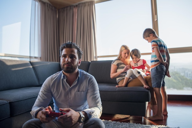 Gelukkig gezin. Vader, moeder en kinderen spelen een videogame Vader en zoon spelen samen videogames op de vloer