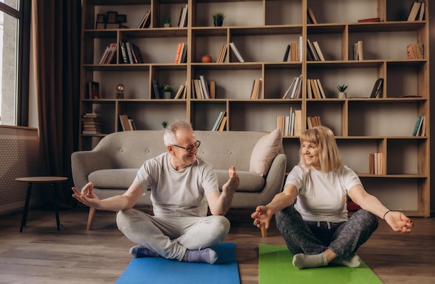 Gelukkig gezond ouder senior jaren '60 paar genieten van fitness sport training training samen in appartement