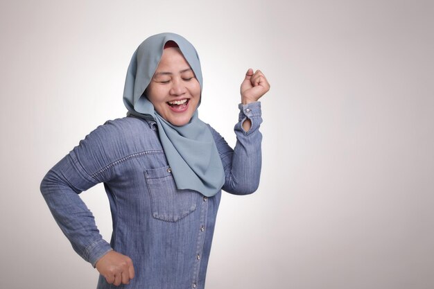 Gelukkig grappige Aziatische moslimvrouw dansen vol vreugde