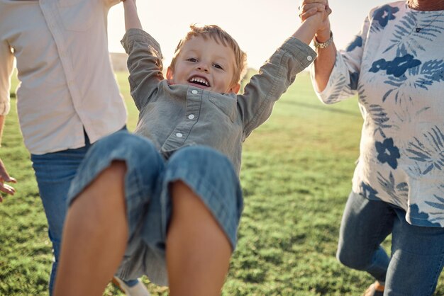 Gelukkig gras en kind hand in hand met ouders op natuurwandeling in een veld op een zomervakantie Gezinsondersteuning en liefde geluk in leuke quality time met jonge jongen wandelen en spelen op vakantie