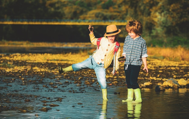 Gelukkig groep klein meisje en jongenskind die plezier hebben in het spelen in de rivier in het zomerkamp in de zomer