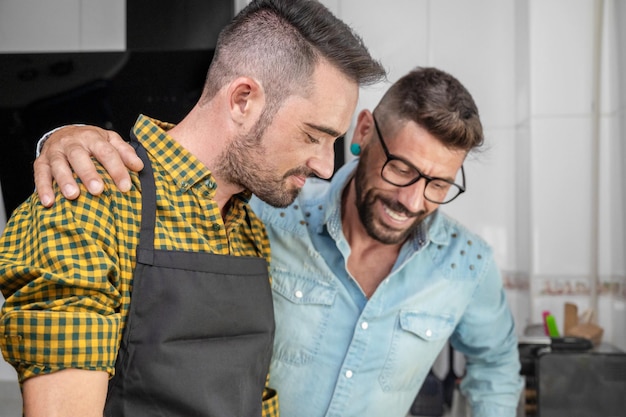 Foto gelukkig hipster homo paar verliefd staande in de keuken ze koken samen thuis eten