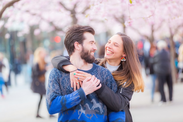 Gelukkig hipsterpaar in Stockholm met kersenbloesems