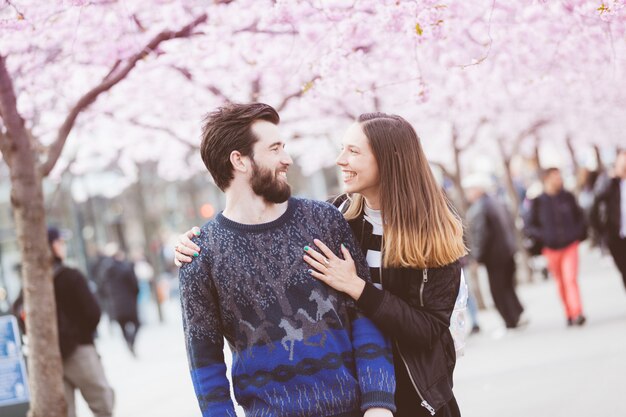 Gelukkig hipsterpaar in Stockholm met kersenbloesems