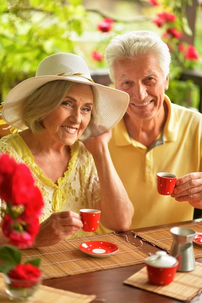 Gelukkig hoger paar dat thuis koffie drinkt op de veranda