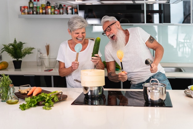 Gelukkig hoger paar die terwijl thuis het koken samen dansen