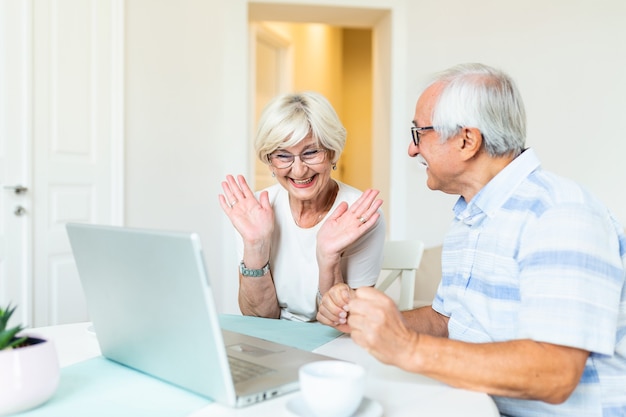 Gelukkig hoger paar met laptop die videogesprek hebben